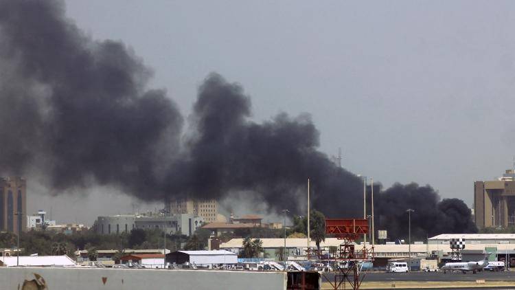 Heavy smoke billows above buildings in the vicinity of the Khartoum airport amid clashes in the Sudanese capital as paramilitaries and the regular army trade attacks on each other's bases. Photo by AFP via Getty Images.