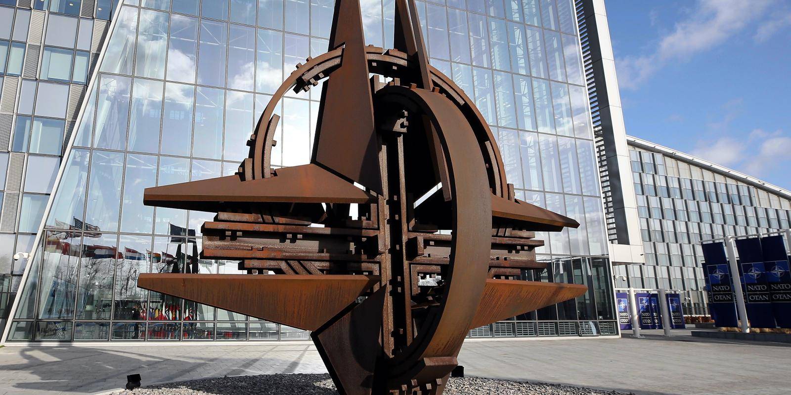 The NATO star sculpture reflected in windows outside NATO headquarters in Brussels, Belgium