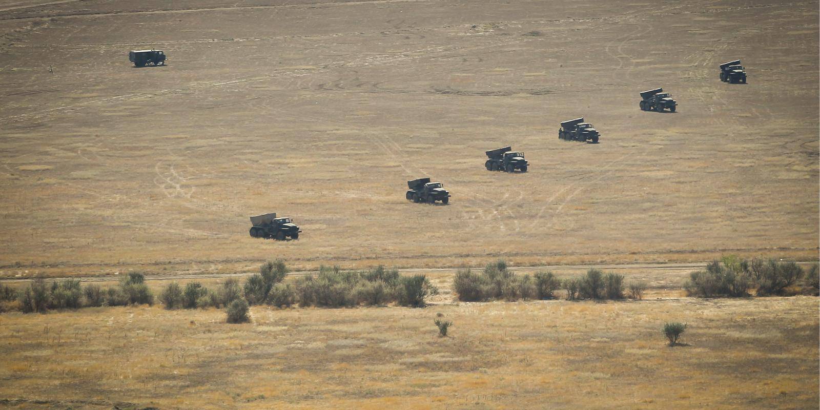 Photo shows vehicles of a Russian motor rifle brigade in line performing military exercises on a plain 