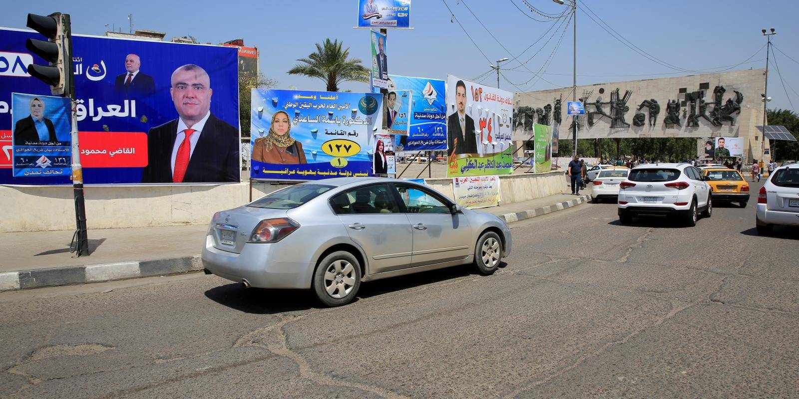 Posters of political candidates line a street in Baghdad.