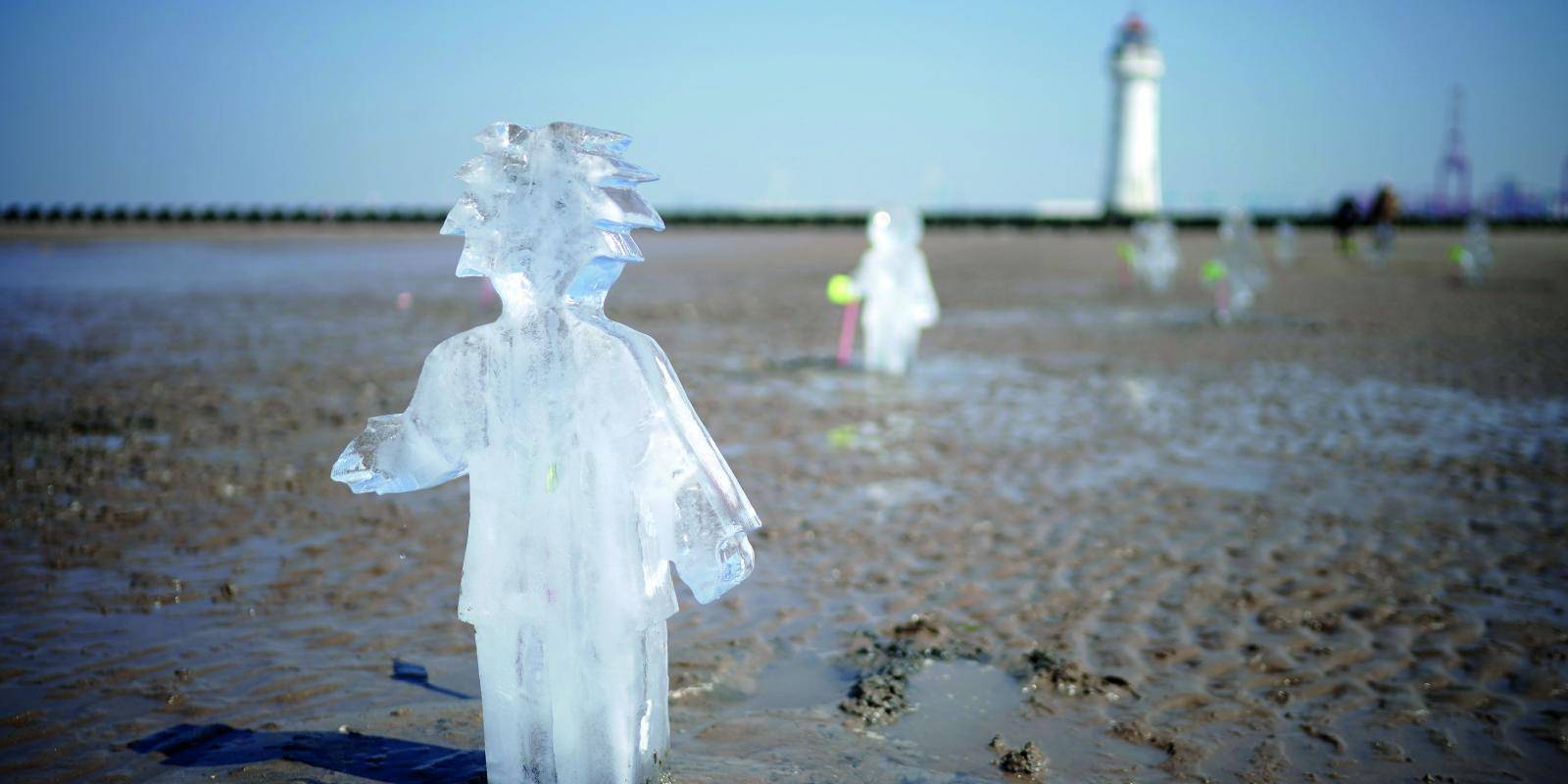 Ice sculptures of children installed on a beach to highlight the climate emergency