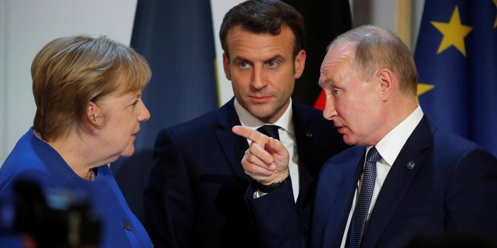 Photo shows French president Emmanuel Macron looking at German chancellor Angela Merkel while Russian president Vladimir Putin points at Merkel