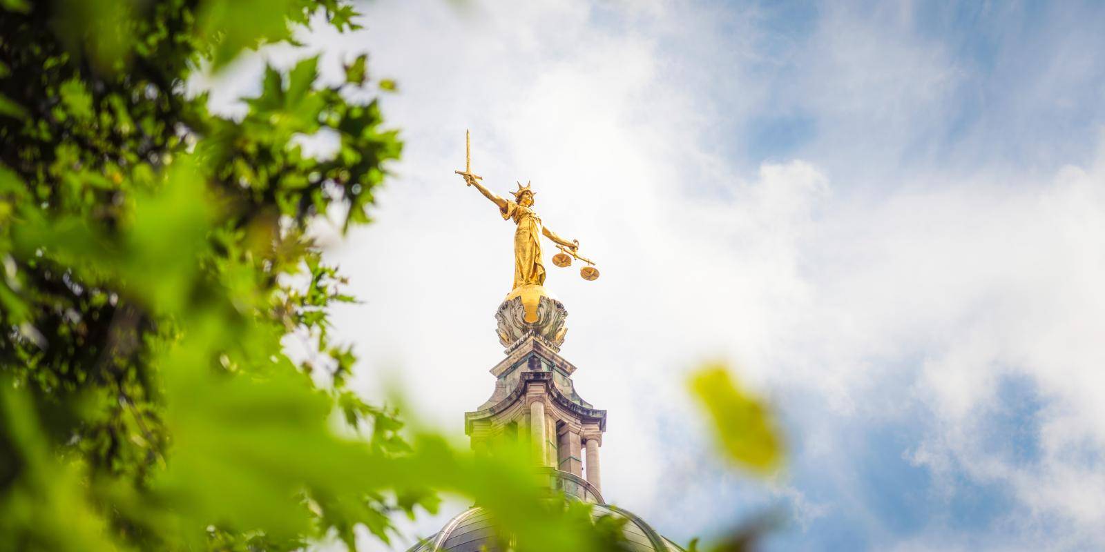 The gold coloured statue of Lady Justice, holding a sword and scales, on top of the dome of the Old Bailey criminal court in the City of London.