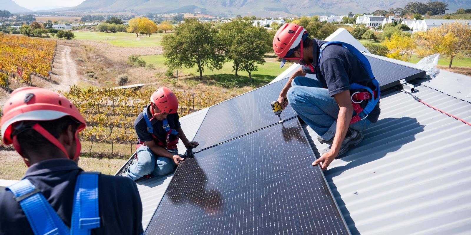 A team of workers install brackets for solar panels on the roof of a house in Cape Town, South Africa.