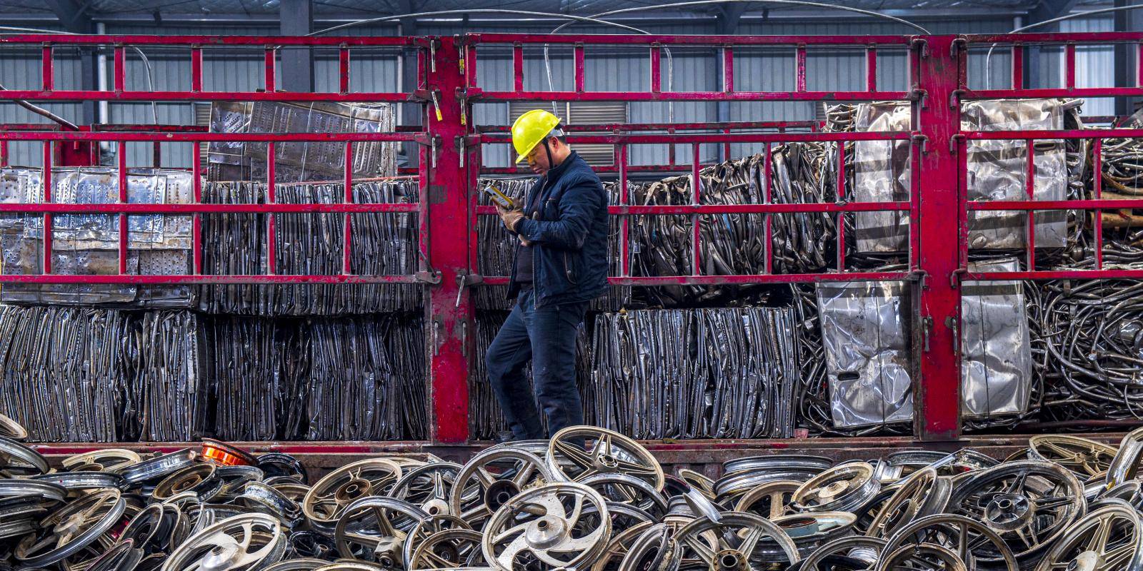 A worker sorts scrap metal to be processed at an aluminium recycling plant in Shaoyang, Hunan Province, China, on 16 December 2021.