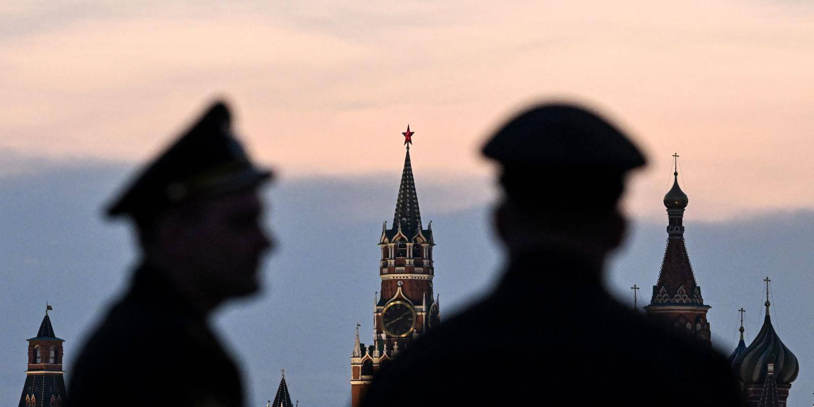 Two soldiers are shown in silhouette against the Kremlin’s Spasskaya tower and St Basil’s cathedral.