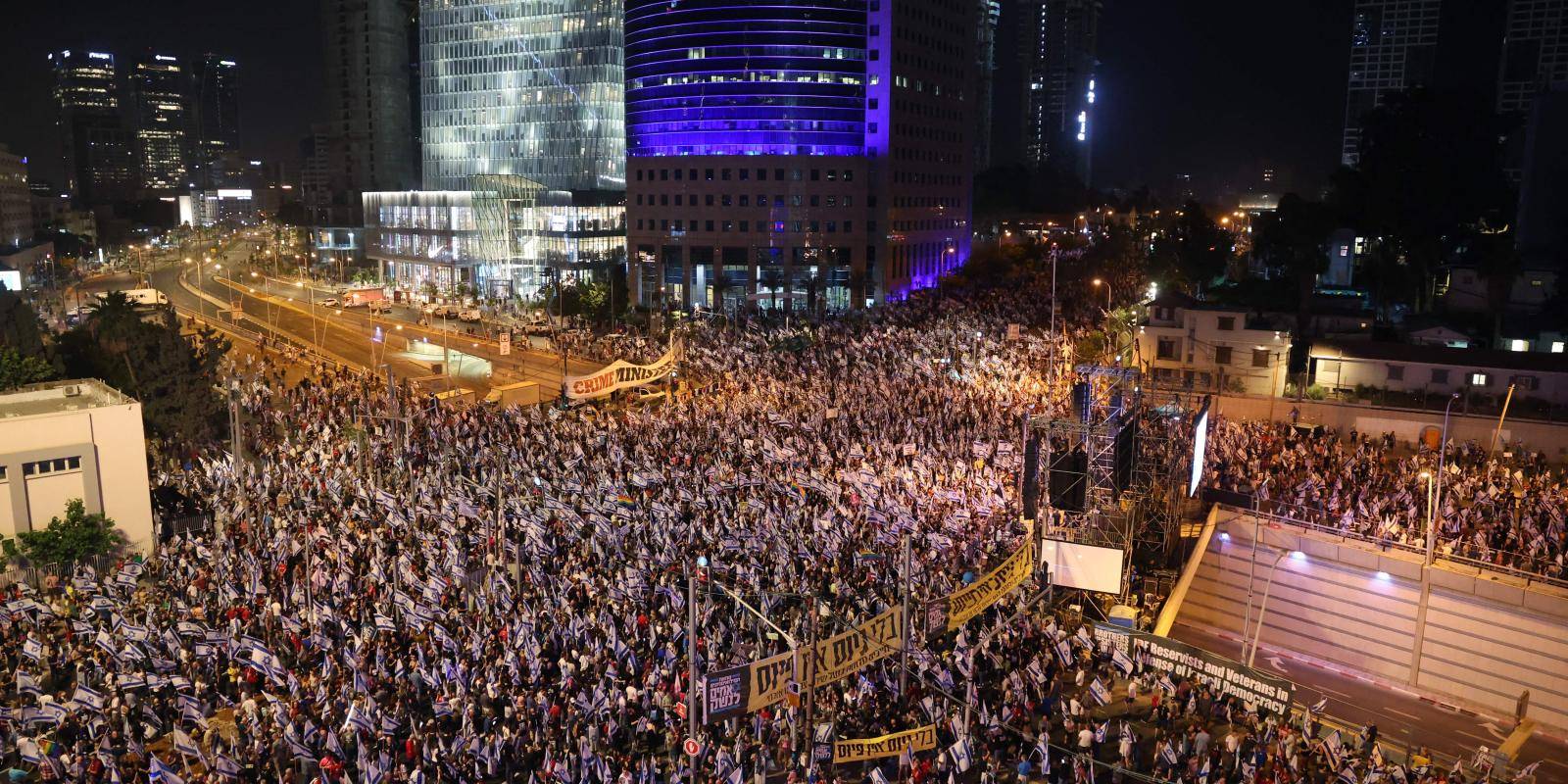 Demonstrators carrying banners and Israeli flags gather in central Tel Aviv to protest against the government's planned changes to the judicial system.