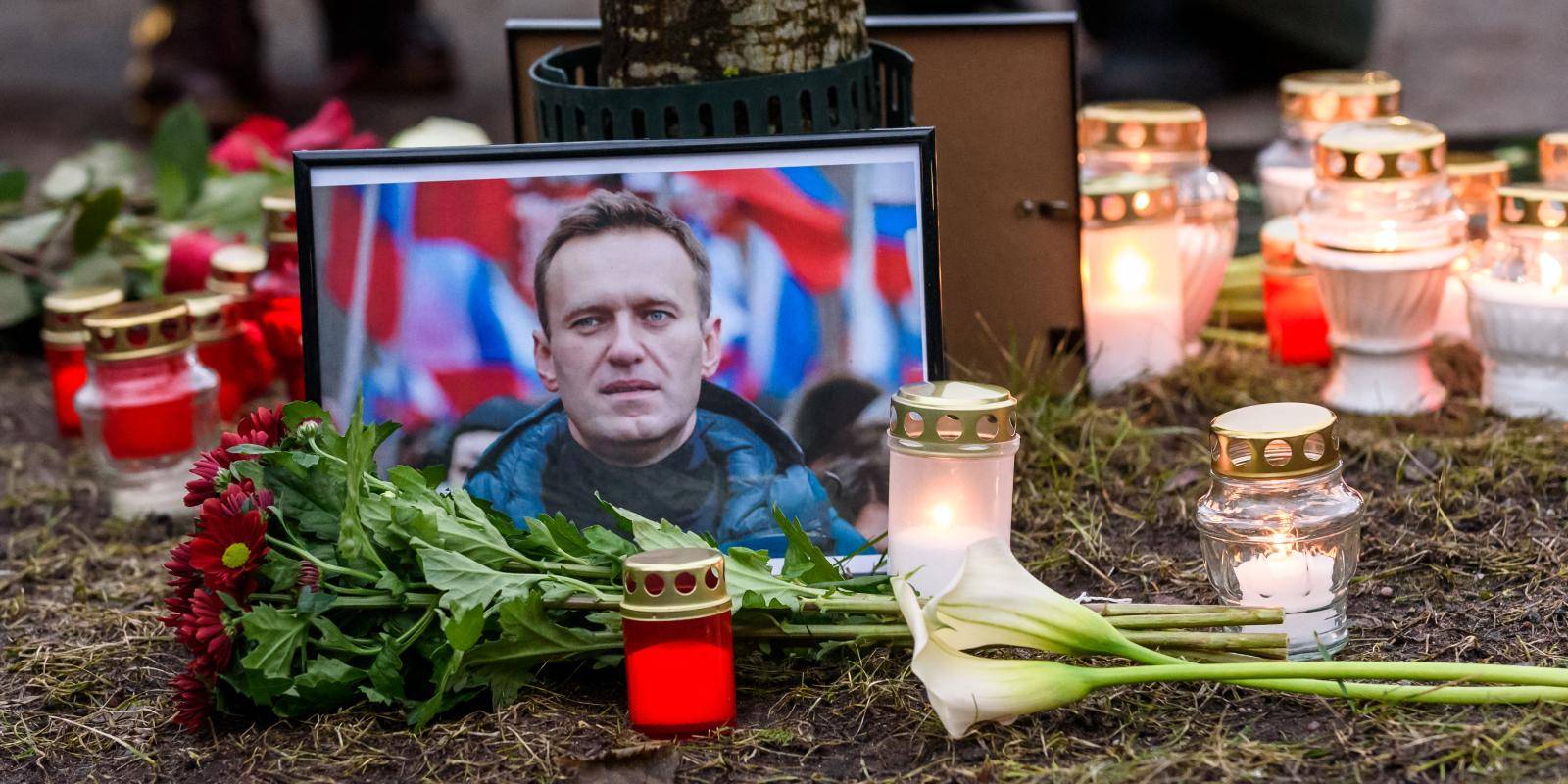 Candles and flowers lay next to a picture of late Russian opposition leader Alexei Navalny as people demonstrate and pay their respect following his death in prison, in front of the Russian Embassy in Riga, Latvia, on 16 February 2024.