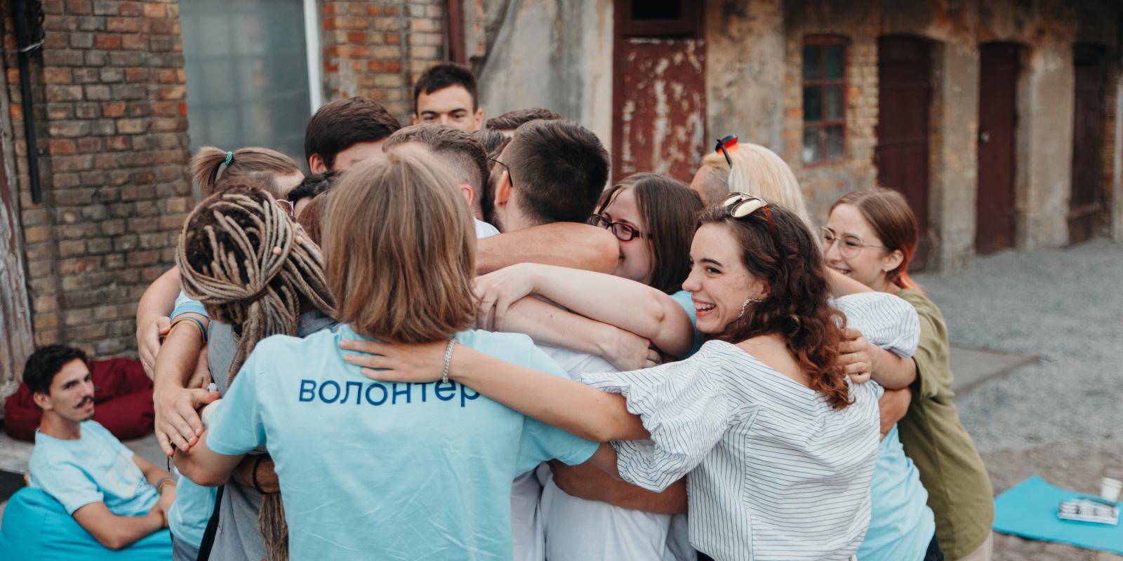 Young volunteers from the NGO Seven Storey Mountain gather together in a huddle.