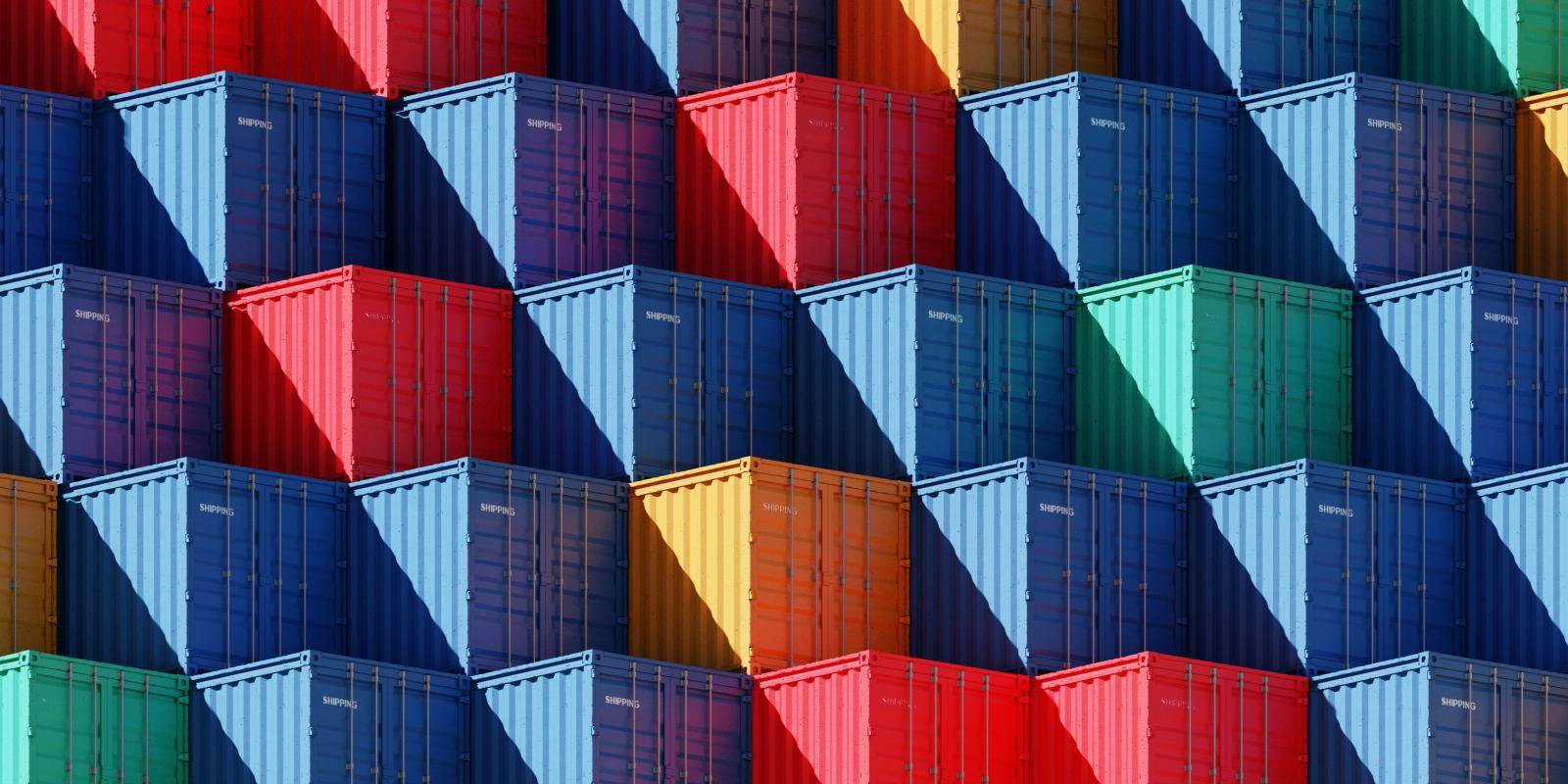 Multicoloured shipping containers piled on top of one another to form a pattern
