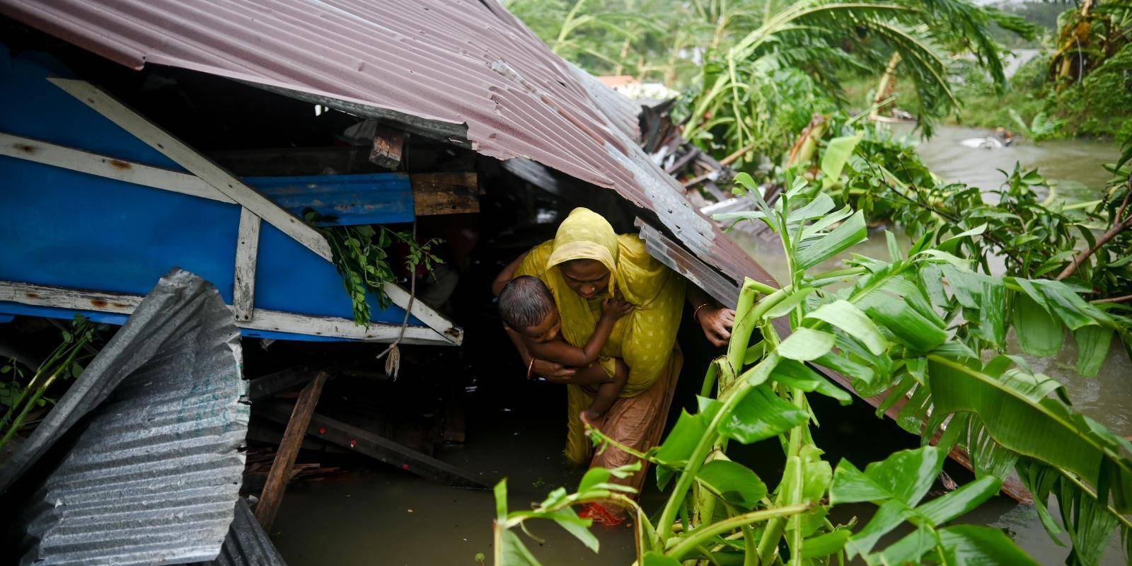 Civilians escape from their flooded home in Bangladesh.