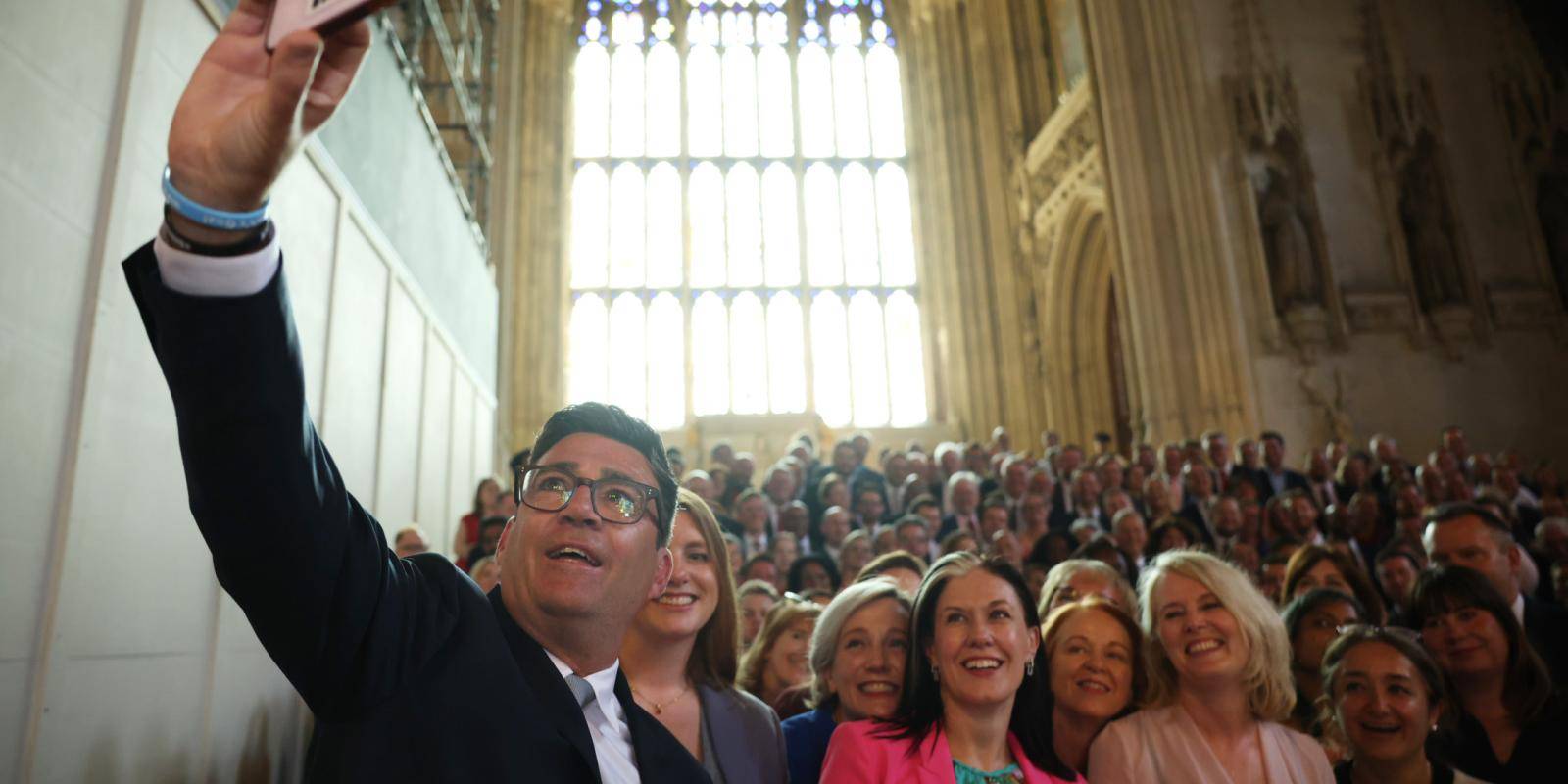 Image of Andy Burnham taking a photo with other MPs in parliament.