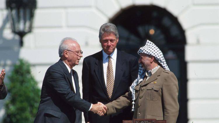 Yasir Arafat and Israeli Prime Minister Yitzhak Rabin shake hands (1993)