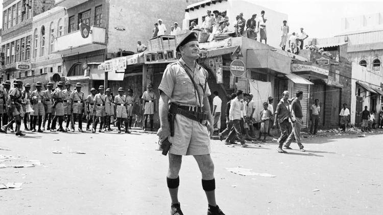 A black and white photo of a British officer standing in Yemen in 1965