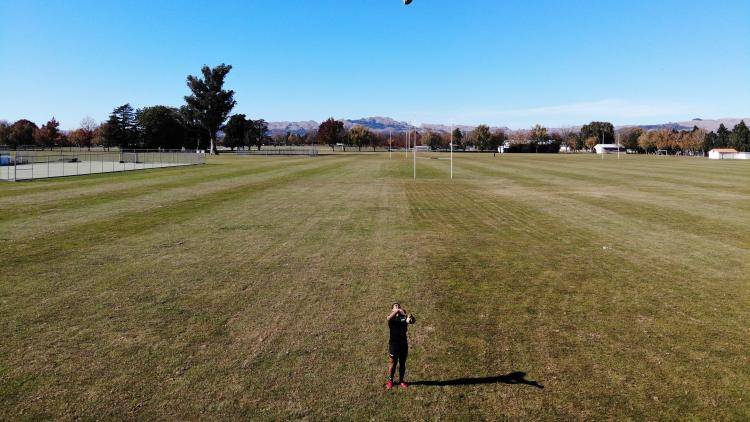 Danny Toala throws a ball in a rugby field