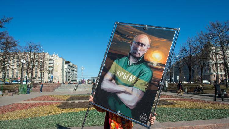 A poster of Vladimir Putin held in the street