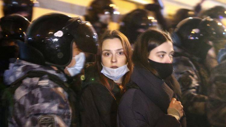 Two young women among riot police participating in a protest