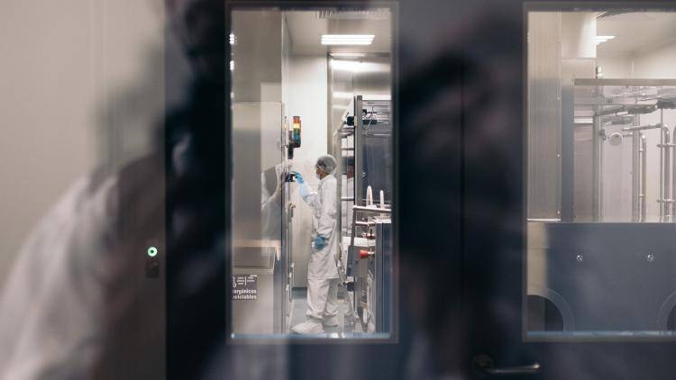 A technician working with glass vials in a laboratory