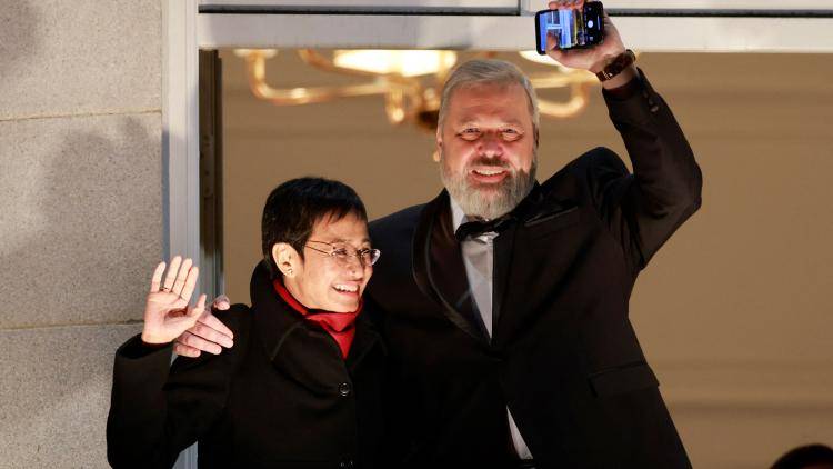 Maria Ressa and Dmitry Muratov wave to people from a balcony in Oslo.