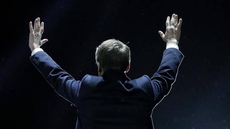 French President Emmanuel Macron greets his supporters at a rally