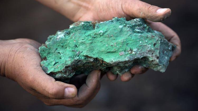 Lump of copper ore in the hands of a miner