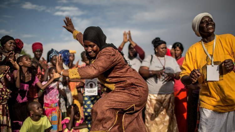 Supporters of Adama Barrow, the flag-bearer of the coalition of the seven opposition political parties in Gambia, dance at the venue of a political rally in Wellingara.