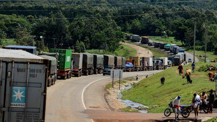 Trucks queue on the road to enter Uganda in Malaba, western Kenya, on April 29, 2020. All truck drivers ferrying goods crossing the border from Kenya must take a test for the COVID-19 by Ugandan health officials and wait 24 hours to get the result. After entering Uganda, the driver must not leave the truck until they reach their destination to unload.