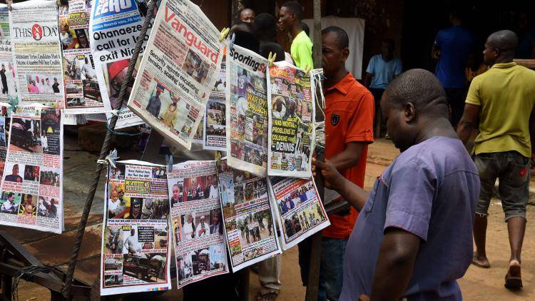 Bystanders read newspapers on a stall in Onitsha, Anambra State, south-eastern Nigeria, on November 5, 2021, on the eve of a governorship election in a ballot being widely anticipated as a barometer for the country's 2023 presidential vote