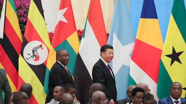  Chinese President Xi Jinping with South African President Cyril Ramaphosa walk past various national flags