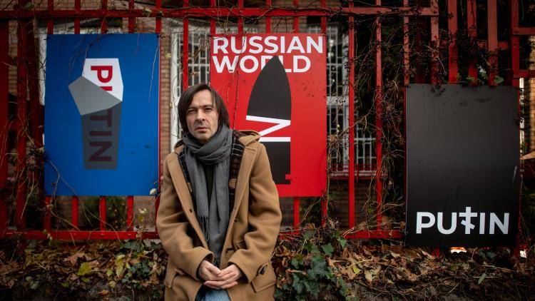 Graphic designer Mykola Kovalenko with a selection of his posters
