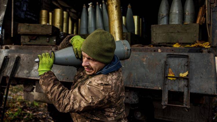 A Ukrainian soldier unloads an artillery shell from the back of a lorry near the front line in the Donetsk region of eastern Ukraine.