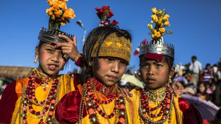 Three tribal Khasis maidens in traditional dress wait their turn at an annual festival in India.