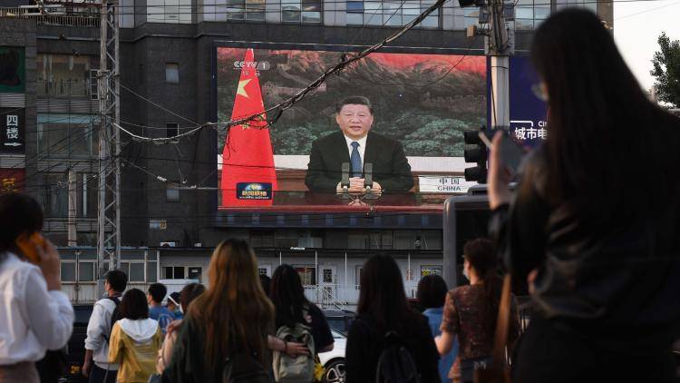 Chinese President Xi Jinping speaking via video link to the World Health Assembly, on a giant screen beside a street in Beijing on 18 May 2020. 