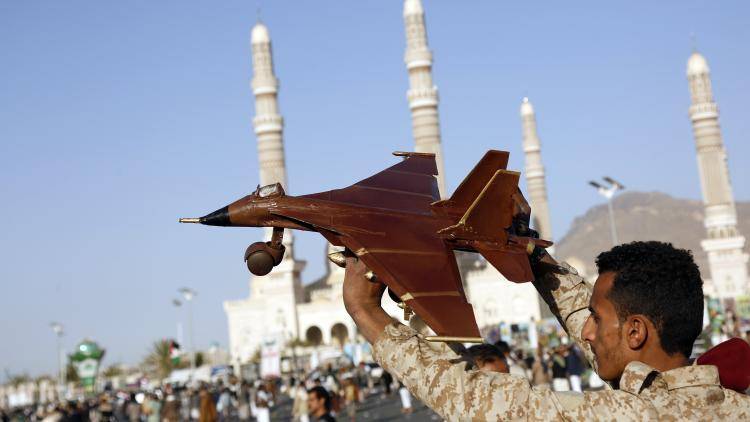 A man lifts a mock jet craft as he participates in a protest staged against violating Yemen's sovereignty through aerial attacks launched by jet crafts of the US and UK, on 12 January 2024 in Sana'a, Yemen. 