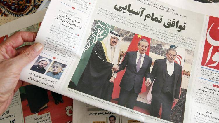 A man in Tehran holds a local newspaper reporting on its front page the China-brokered deal between Iran and Saudi Arabia to restore ties.