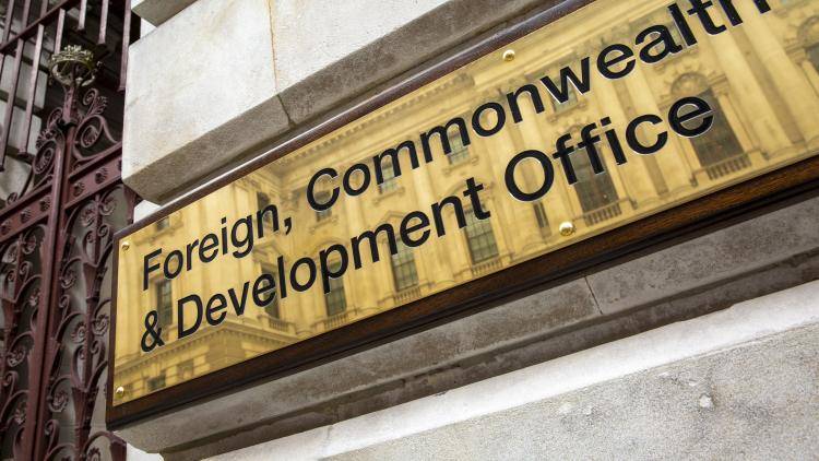 The Foreign, Commonwealth, and Development Office brass plaque sign outside the office building in Westminster, London, United Kingdom.