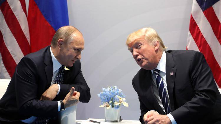 Vladimir Putin speaking with Donald Trump, with Russia and US flags behind them 