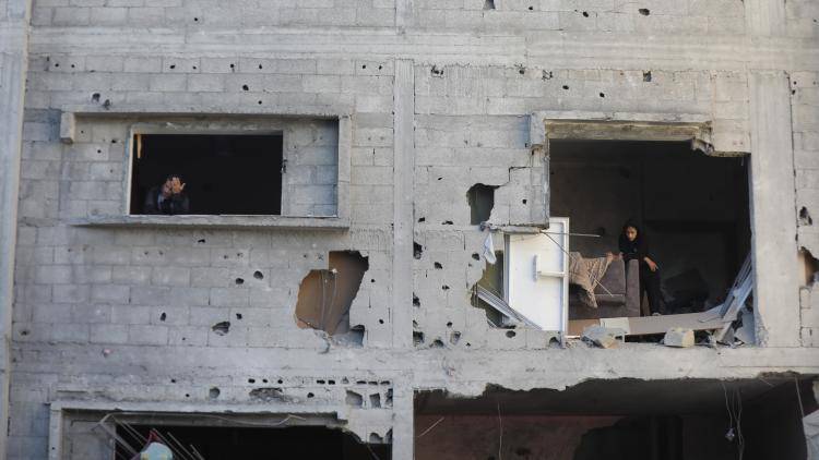 Residents looking out from a building damaged by Israeli raids 