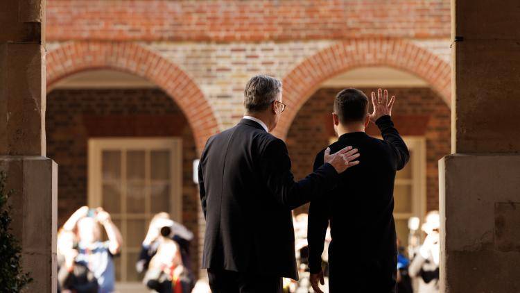 Keir Starmer and Ukrainian President Volodymyr Zelenskyy waving, pictured from behind
