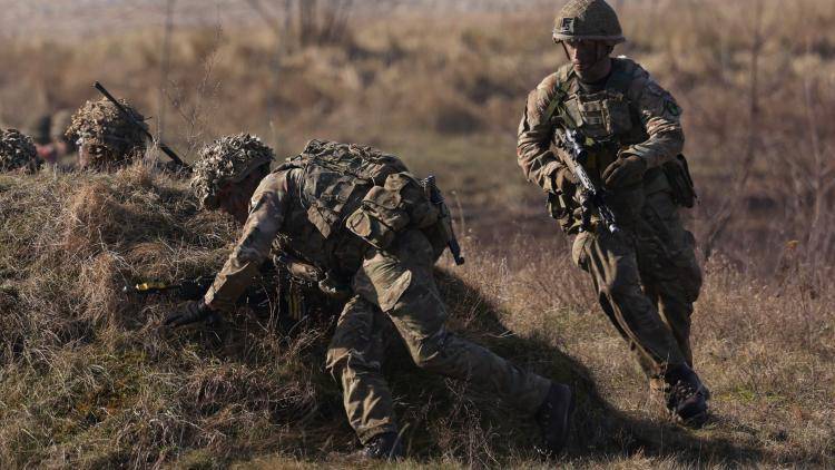 Soldiers of the United Kingdom's 2nd Battalion Royal Anglian infantry unit storm an enemy position in a simulated attack during the NATO "Brilliant Jump" military exercises.