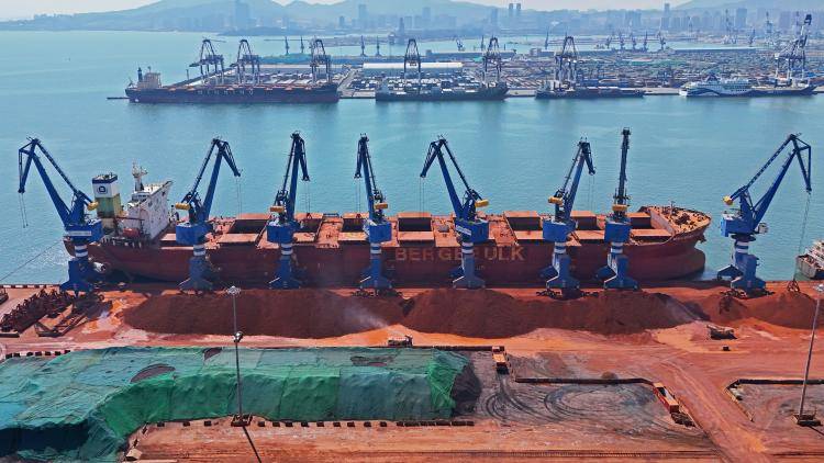  freighter performs a bauxite unloading operation at the ore berth of Yantai Port in Yantai, Shandong province