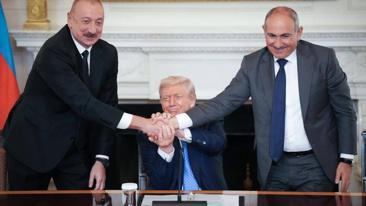 US President Donald Trump (C) joins hands with Azerbaijani President Ilham Aliyev (L), and Armenian Prime Minister Nikol Pashinyan (R) during a signing ceremony in the State Dining Room of the White House.