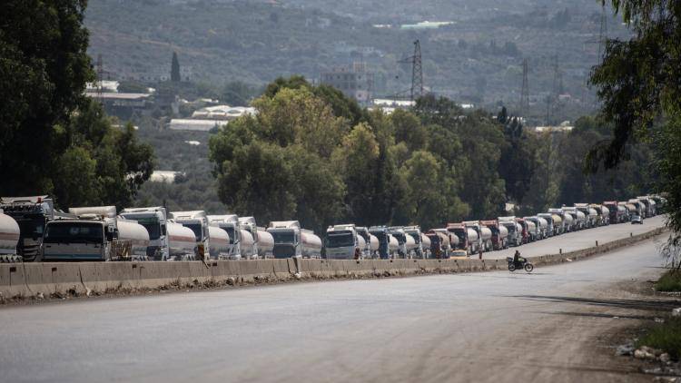 Trucks waiting to offload crude oil onto a tanker ship at the Banyas Oil Terminal in Tartus, Syria
