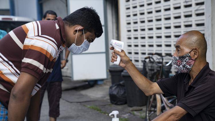 A migrant worker in Singapore has his temperature checked 
