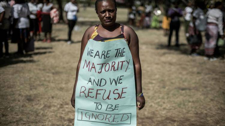 A woman poses with a message as hundreds of activists marched to protest repeated failures to apply laws that women must hold at least a third of government seats in Nairobi, Kenya, on 22 January 2018. Photo: Getty Images.