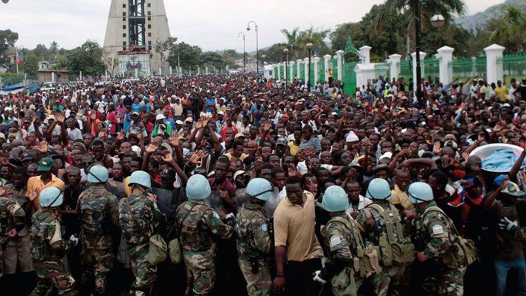 Haitians, queuing in their thousands for rice after the 2010 earthquake, are allowed through one at a time by UN peacekeepers. Photo: Chris Hondros/Getty Images