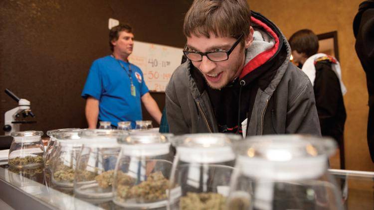 A customer picks marijuana strains to buy at a Denver dispensary. Photo: Theo Stroomer/Getty
