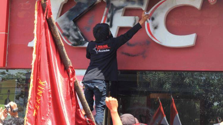 Indonesian students scrawl graffiti on a KFC outlet. Photo: FP/AFP/Getty Images