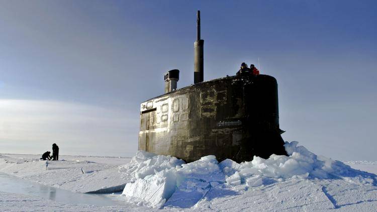 The USS Connecticut surfaces through the polar ice. Below, a Norwegian soldier quides in a NATO helicopter. Photo: Getty Images/Stocktrek