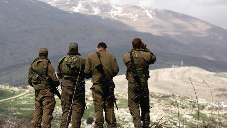 Israeli soldiers deployed on the border look towards Syria. Photo: Menahem Kahana/AFP/Getty